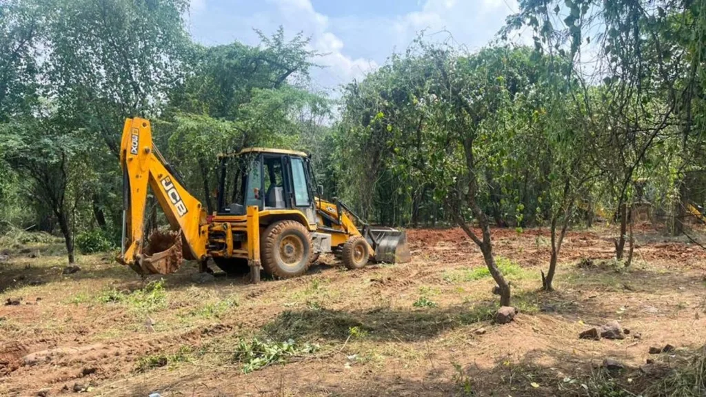 Heavy JCB earthmoving equipment clearing native trees and leveling land for linear infrastructure expansion. Photo Credit: Mongabay India / PFWCI Conservation Cell.